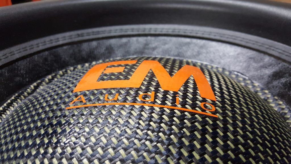 Carbon fiber dust cap with an orange EM Audio logo